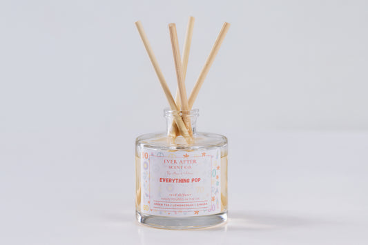 Ever After Scent Co Everything POP Reed diffuser with wooden sticks in a glass bottle on a light gray background